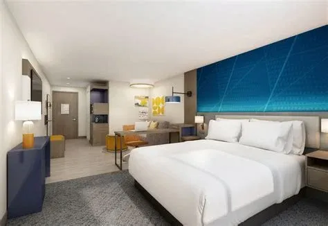 Hotel guest room at a Comfort Inn with headboard wall, desk, and seating