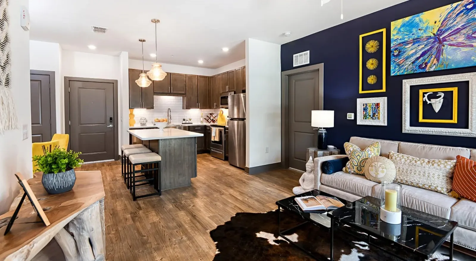 Furnished apartment at Newberry with dark cabinetry, island seating, and pendant lighting